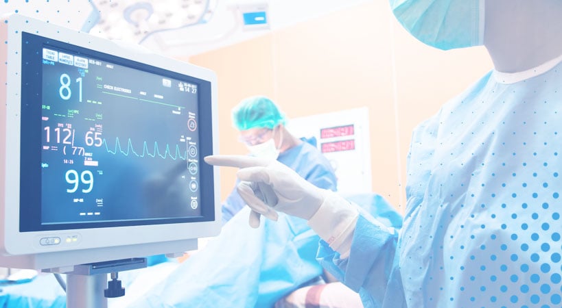Surgical team checking screen for vitals